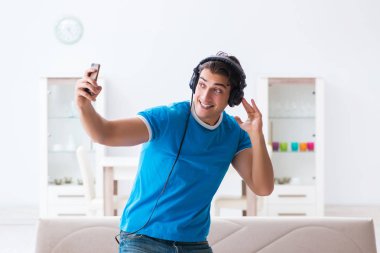 Genç yakışıklı adam evde karaoke yapıyor. 