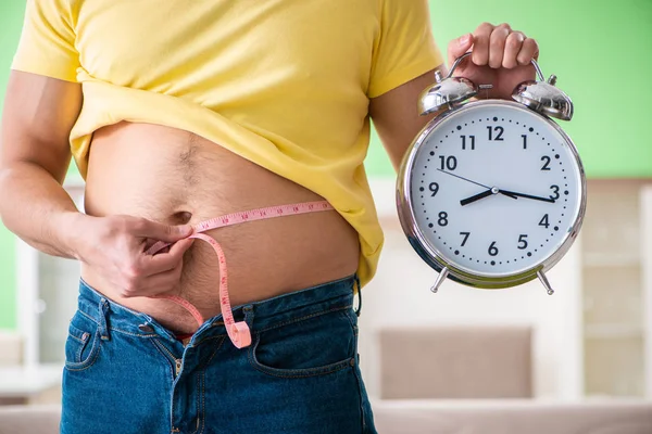 Man measuring body fat with tape measure in time management conc — Stock Photo, Image