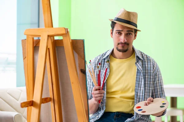 Mladý umělec pracuje na nové malbě ve svém ateliéru — Stock fotografie