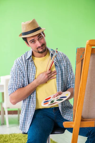 若い男性アーティストは彼のスタジオで新しい絵画に取り組んでいます — ストック写真
