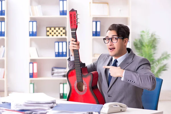 Jeune homme d'affaires beau jouant de la guitare dans le bureau — Photo