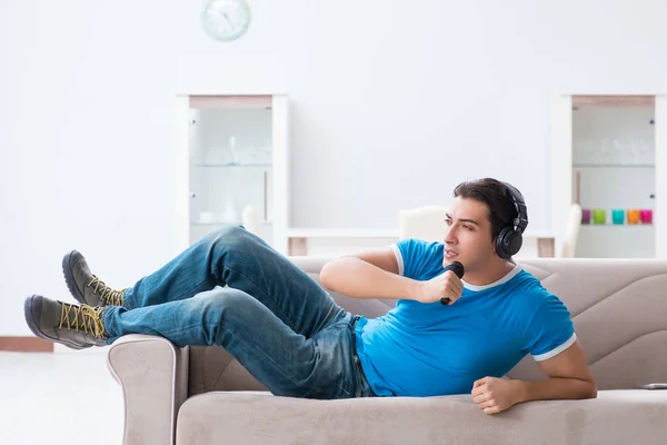 Joven hombre guapo cantando karaoke en casa —  Fotos de Stock