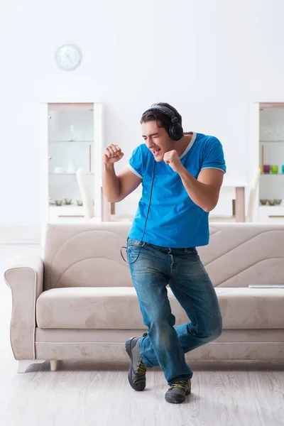 Молодой красивый мужчина слушает музыку и веселится дома — стоковое фото