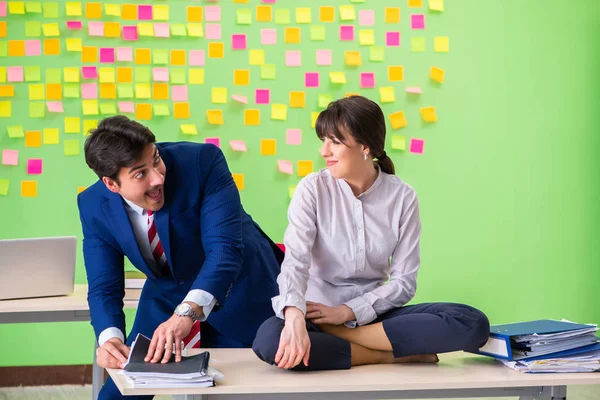 Man and woman in the office with many conflicting priorities in yoga concept