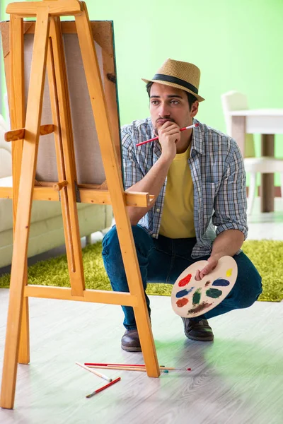 Jovem artista masculino trabalhando em nova pintura em seu estúdio — Fotografia de Stock