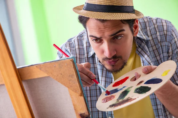 Joven artista masculino trabajando en una nueva pintura en su estudio — Foto de Stock