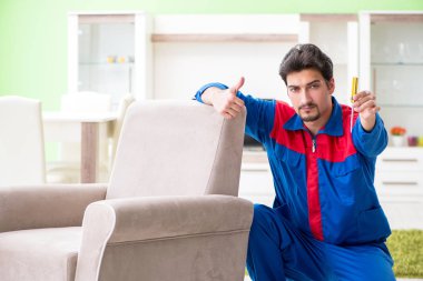 Müteahhit evde kırık mobilyaları tamir ediyor.