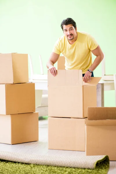 Joven hombre guapo mudándose a casa nueva con cajas —  Fotos de Stock