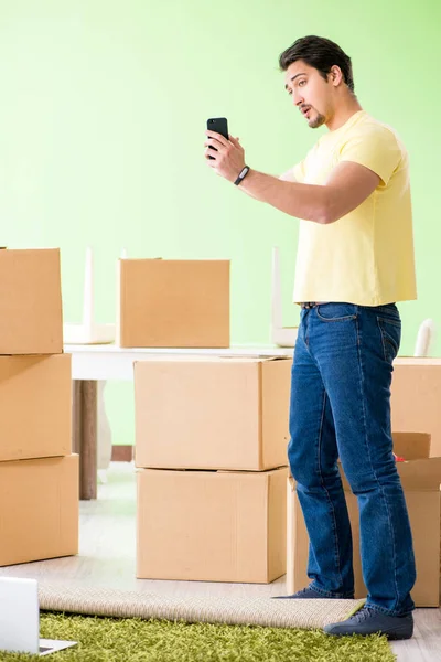 Young handsome man moving in to new house with boxes