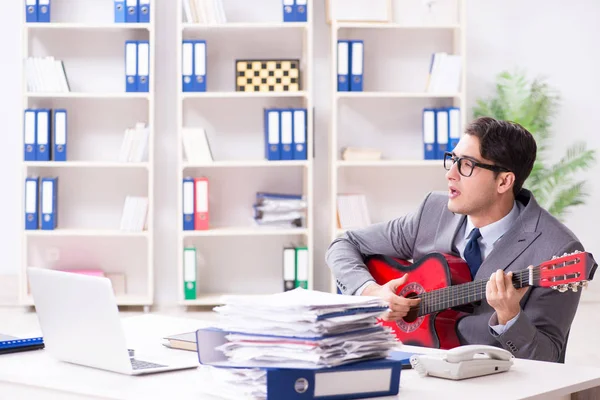 Jeune homme d'affaires beau jouant de la guitare dans le bureau — Photo