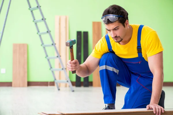 Empreiteiro profissional que coloca piso em casa — Fotografia de Stock