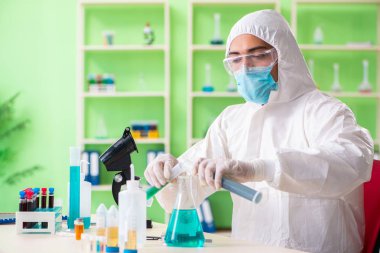 Laboratuvarda yeni bir deney üzerinde çalışan kimyager.