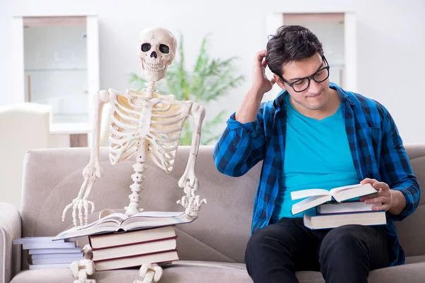 Studentin mit Skelett bereitet sich auf Prüfungen vor — Stockfoto