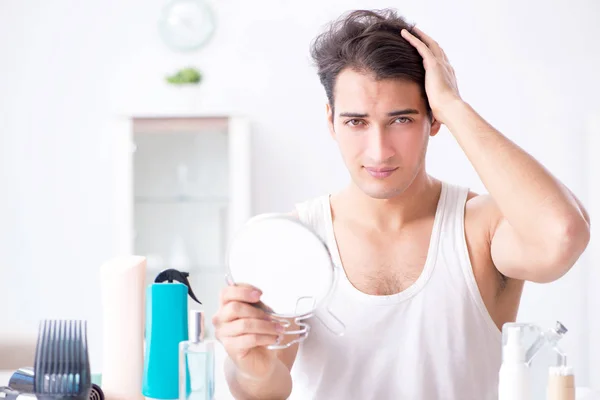 Joven hombre guapo mirando al espejo — Foto de Stock