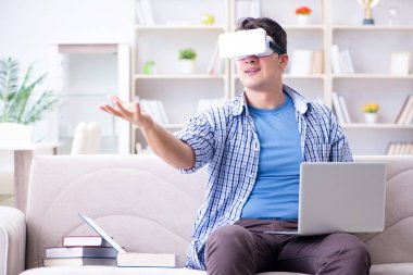 Evde sanal gerçeklik gözlükleriyle serbest çalışan bir öğrenci.