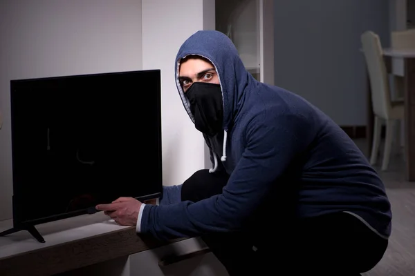 Burglar thief stealing tv from apartment house — Stock Photo, Image