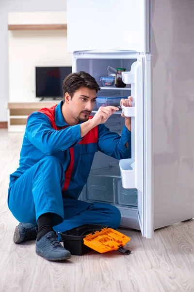 Professional contractor repairing broken fridge