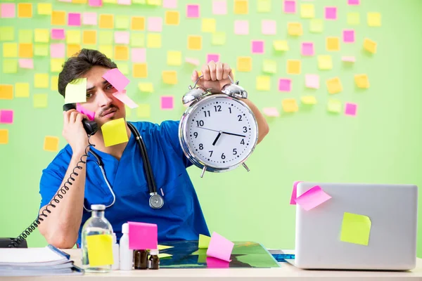 Médico joven con muchos recordatorios y trabajo urgente — Foto de Stock