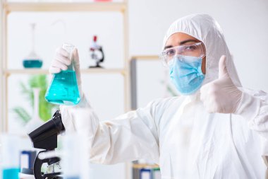 Laboratuvarda kimyasallar üzerinde çalışan genç bir kimyager.