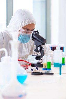 Laboratuvarda kimyasallar üzerinde çalışan genç bir kimyager.