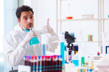 Laboratuvarda kimyasallar üzerinde çalışan genç bir kimyager.