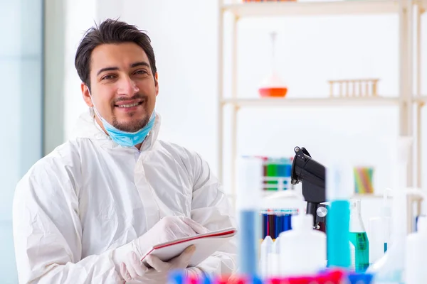 Joven estudiante de química trabajando en laboratorio sobre productos químicos —  Fotos de Stock