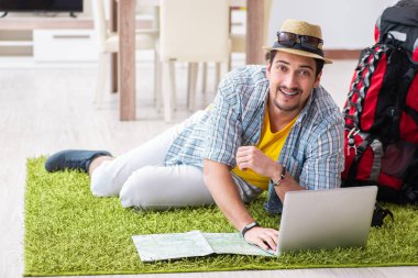 Genç adam internetten seyahat etmeyi planlıyor.