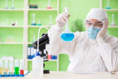 Laboratuvarda yeni bir deney üzerinde çalışan kimyager.