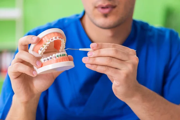 Hombre dentista trabajando en un nuevo implante dental — Foto de Stock