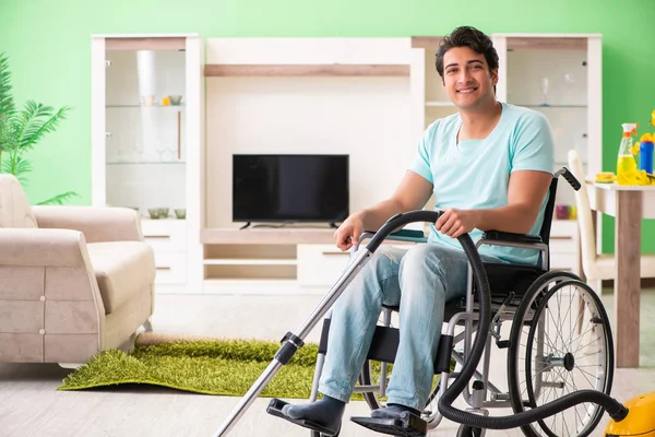 Homem com deficiência em cadeira de rodas casa de limpeza a vácuo — Fotografia de Stock