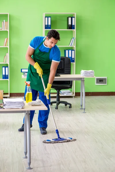 Masculino bonito profissional de limpeza fazendo esfregar no escritório — Fotografia de Stock