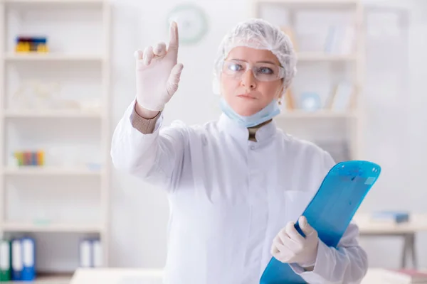 Kvinna läkare trycker på knappar i labbet — Stockfoto