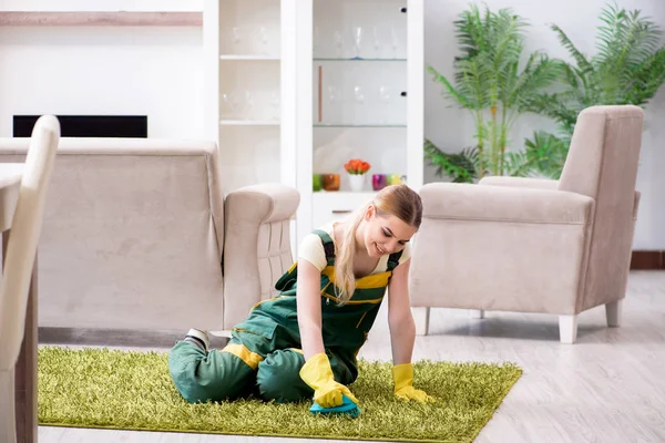 Professional female cleaner cleaning carpet