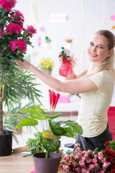 Jovem mulher regando plantas em seu jardim — Fotografia de Stock