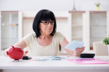 Faturalarını ödemeye çalışan olgun bir kadın.