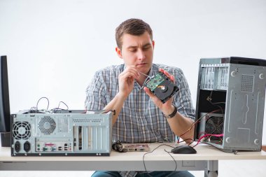 Genç teknisyen atölyede bilgisayar tamir ediyor.