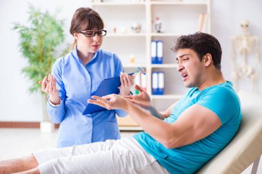 Doktor çekiçle sinir reflekslerini kontrol ediyor