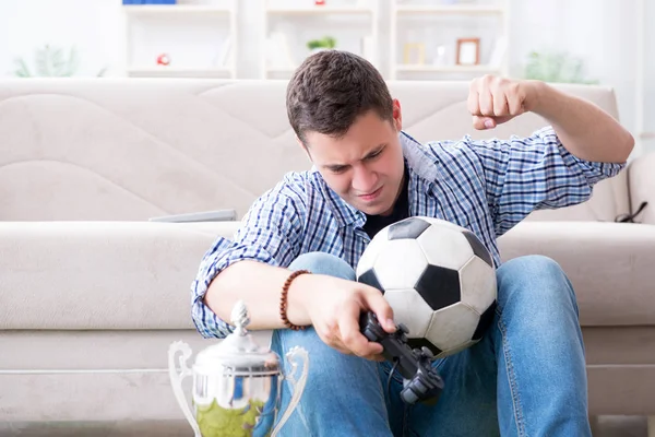 Genç adam evde bilgisayar oyunu oynuyor.