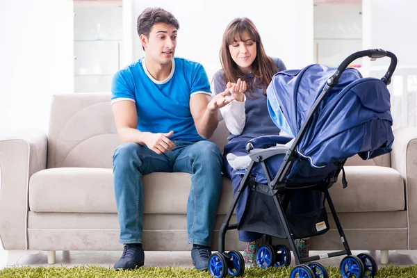 Unga föräldrar med sitt nyfödda barn i barnvagn sitter på th — Stockfoto