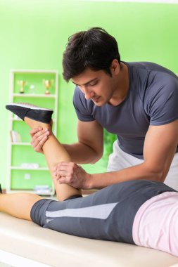 Genç doktor masör hastaya masaj yapıyor. 