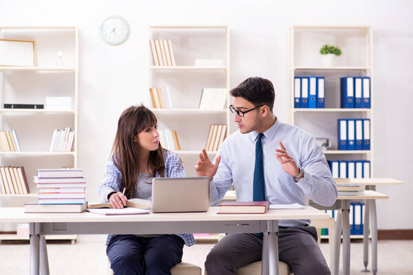 Male lecturer giving lecture to female student