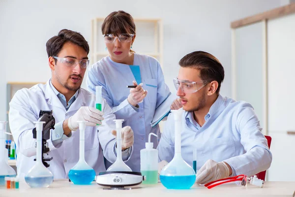 Equipe de químicos que trabalham no laboratório — Fotografia de Stock