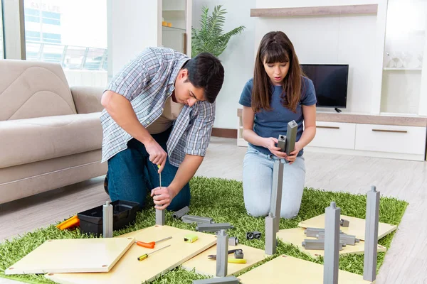 Young family assembling furniture at new house — Stock Image Young family assembling furniture at new house Royalty Free Stock Photos