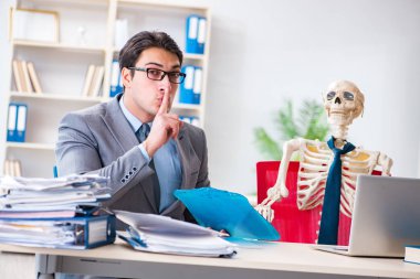 İskeletle çalışan bir iş adamı.