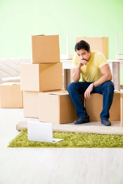 Young handsome man moving in to new house with boxes — Stock Photo, Image