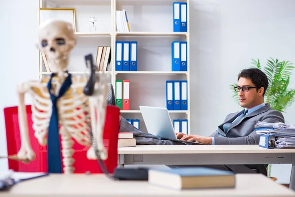 Businessman working with skeleton in office — Stock Photo, Image