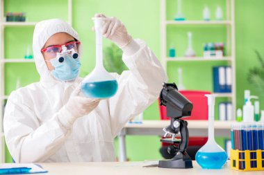 Laboratuvarda yeni bir deney üzerinde çalışan kimyager.