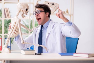 Çılgın profesör insan iskeleti üzerinde çalışıyor.