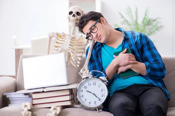 Студент, обучающийся со скелетом, готовится к экзаменам — стоковое фото