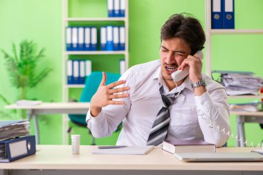 Hasta ve mutsuz iş adamı ofiste oturuyor. 